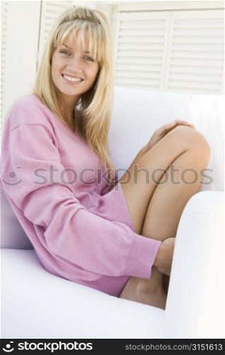 Blonde woman in a pink sweater posing outdoors