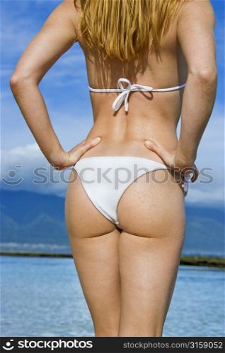 Blonde woman in a white bikini, sea background