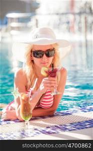 Blonde woman in hat at the swimming pool. Woman in swimming pool