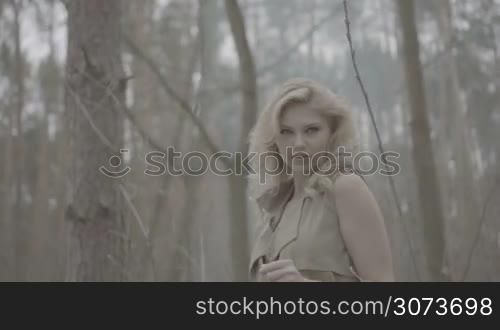 blonde woman in the forest looking like trying to escape from the scene