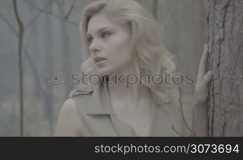 blonde woman in the forest with the smoke behind