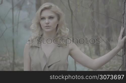 blonde woman in the forest with the smoke from behind