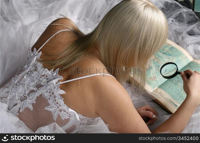 Blonde woman looking through a magnifying glass