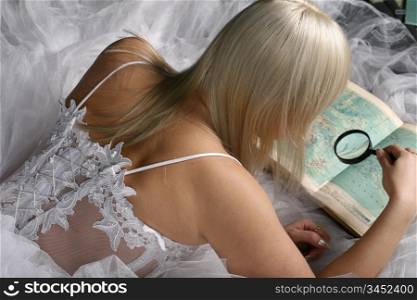 Blonde woman looking through a magnifying glass