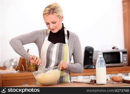 blonde woman making a cake