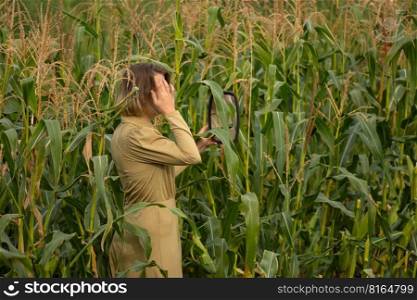 Blonde woman model with natural makeup and healthy skin over corn field at sunset. Happy emotional woman enjoying life.. Beauty and fashion model among tall green corn plants on a rural field. Happy woman with a smile on face.