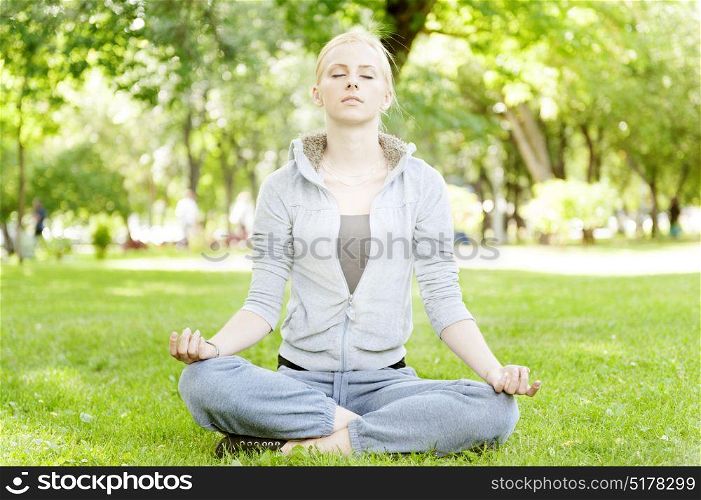 Blonde woman practise yoga and meditatation at the park