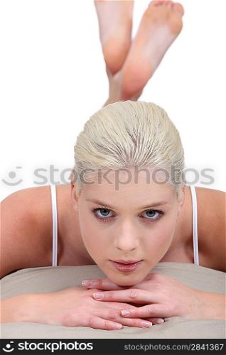 blonde woman resting on a bed