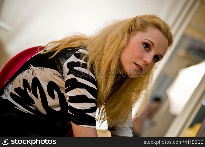 Blonde woman sits looking away from camera
