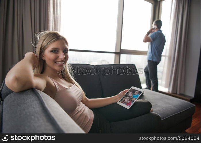 Blonde Woman Sitting On A Sofa Using Her Tablet