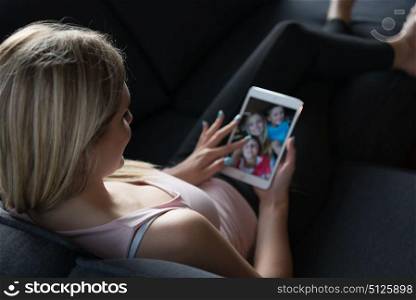 Blonde Woman Sitting On A Sofa Using Her Tablet
