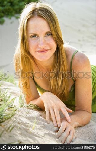 Blonde woman smiling on sand