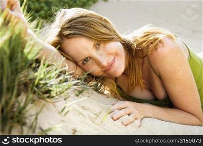 Blonde woman smiling on sand