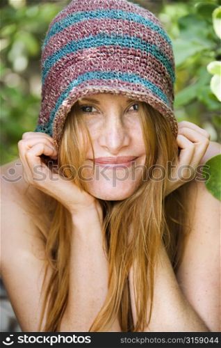 Blonde woman smiling, wearing stripped hat