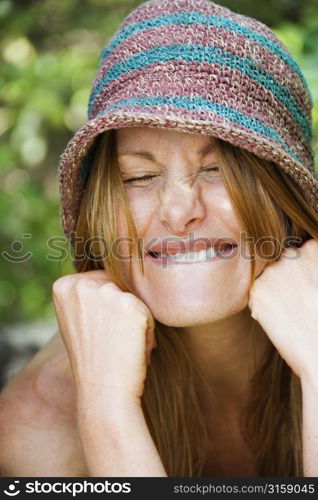 Blonde woman smiling, wearing stripped hat