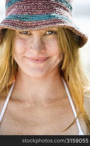 Blonde woman smiling, wearing stripped hat