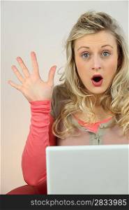 blonde woman surprised behind a computer