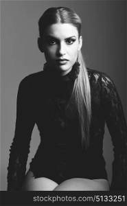 Blonde woman wearing shirt with a ponytail. Studio shot. Black and white photograph.