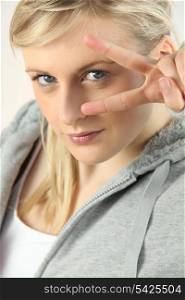 Blonde woman with fingers in V shape