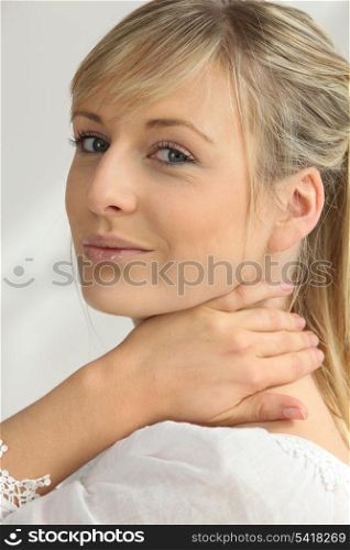 Blonde woman with hand on neck