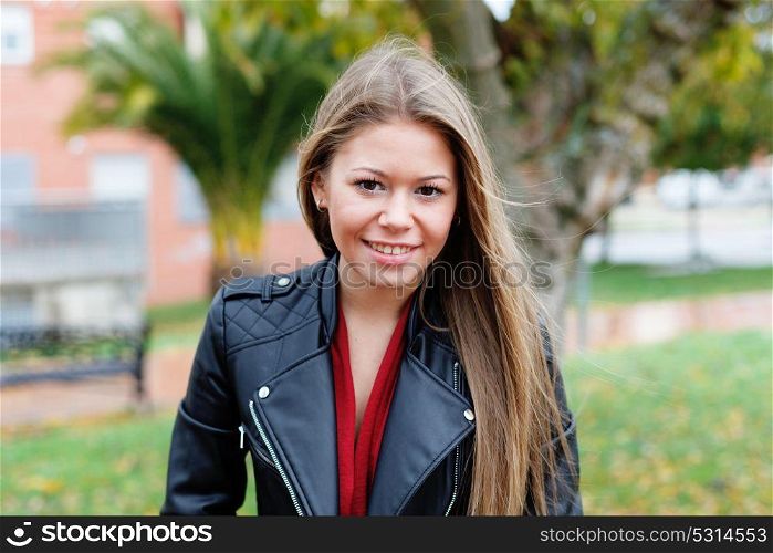 Blonde woman with leather jacket in a park