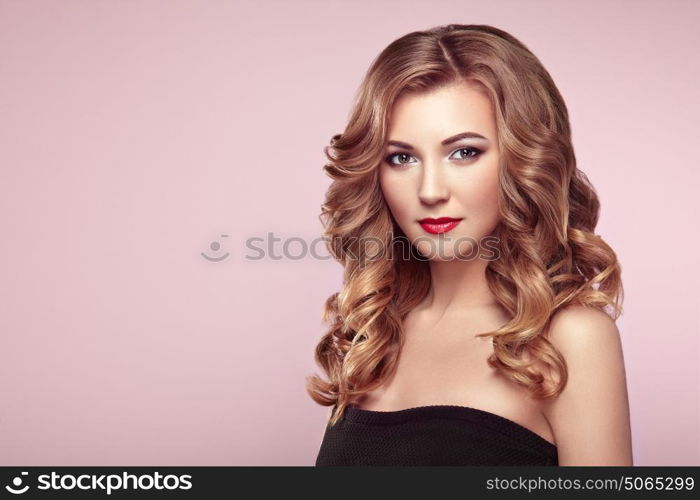 Blonde woman with long and volume shiny wavy hair . Beautiful model with curly hairstyle. Perfect make-up. Beauty style model