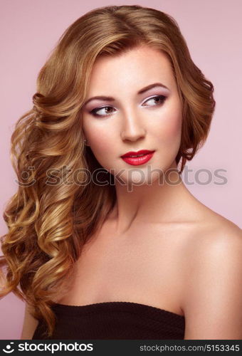 Blonde woman with long and volume shiny wavy hair . Beautiful model with curly hairstyle. Perfect make-up. Beauty style model