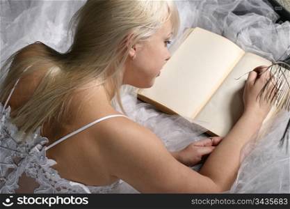 Blonde woman writing in a book