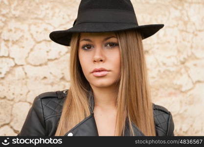 Blonde young woman with black hat and leather jacket