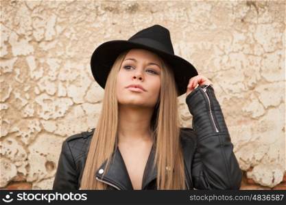 Blonde young woman with black hat and leather jacket