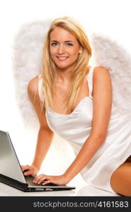 Blonder Engel zu Weihnachten nimmt Wunsche mit Laptop an.