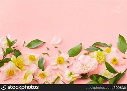 Blossiming pattern flowers with green leaves on a color background of the year 2019 Living Coral Pantone, place for text. Wedding, Women's Day.. Decorative frame from spring flowers on a color background of the year 2019 Living Coral Pantone. Mother's Day. Flat lay.