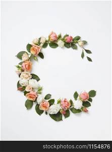 Blossoming corner flowers wearth from coral roses with green leaves on a light grey background, copy space. Flat lay. Valentine&rsquo;s Day concept.. Round corner frame from roses flowers.