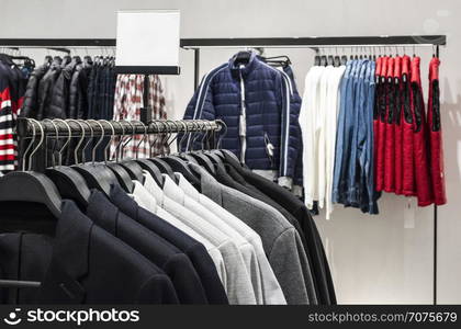 Blouses and jeans on shelf in fashion clothing store. Casual clothes in shop. Commercial and fashion concept.