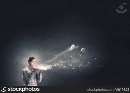 Blow dust from pages. Young businessman with opened book in hands blowing on pages