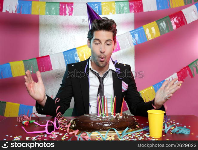 Blowing a holiday party chocolate cake young handsome suit man