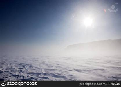 Blowing snow across a desolate winter landscape