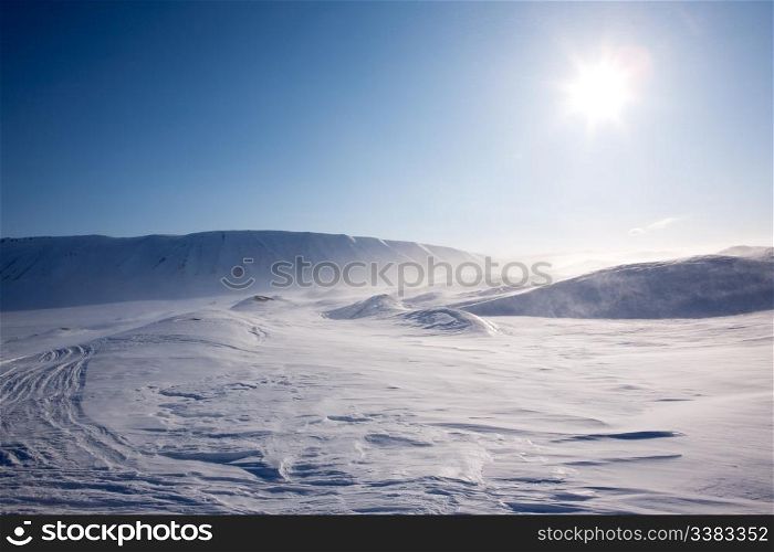 Blowing snow in a barren winter mountain landscape