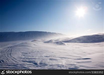 Blowing snow in a barren winter mountain landscape