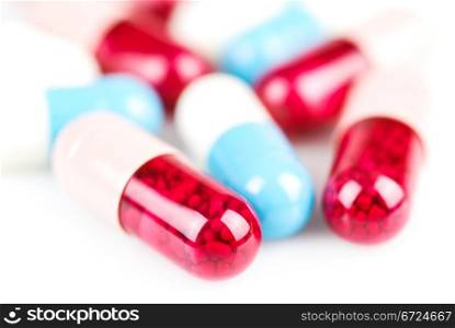 Blue and red capsules on white background