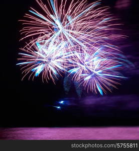 Blue and red colorful holiday fireworks on the black sky background.