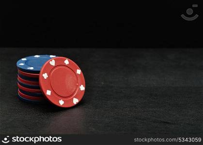 Blue and red poker chips on a black background