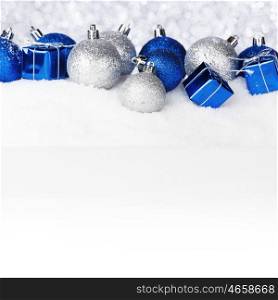 Blue and silver christmas balls and decoration on snow