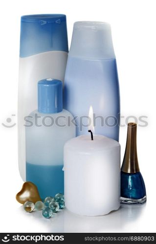 blue and white bottles with different cosmetics and a burning white candle