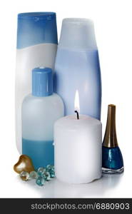 blue and white bottles with different cosmetics and a burning white candle