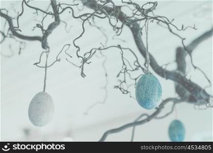 Blue and white easter eggs hanging on a branch