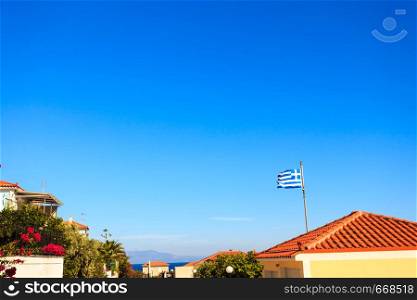 Blue and white Greek flag waving on wind in town. National landmark concept. Blue and white Greek flag waving on wind
