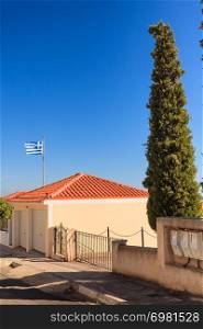 Blue and white Greek flag waving on wind in town. National landmark concept. Blue and white Greek flag waving on wind