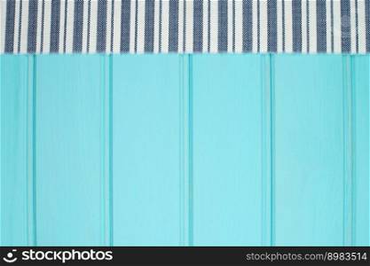 Blue and white towel over the surface of a wooden table.