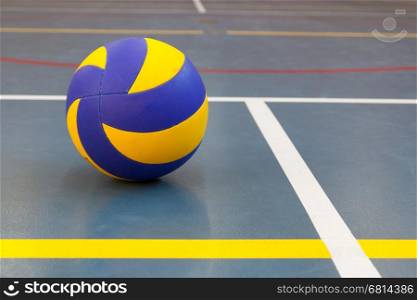 Blue and yellow ball on blue court at break time, school gym
